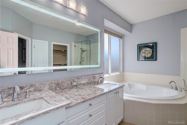 a bathroom with a granite countertop sink and a large mirror