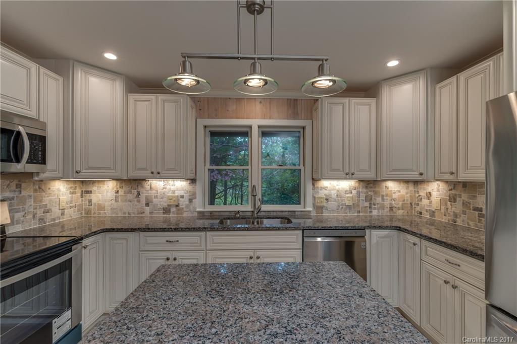 81 Jericho Drive Tryon, NC 28782 - Photo 5 of 23 a kitchen with stainless steel appliances granite countertop a sink a stove a microwave and cabinets