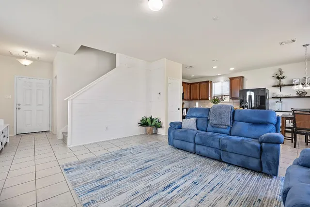 a living room with furniture and a view of kitchen