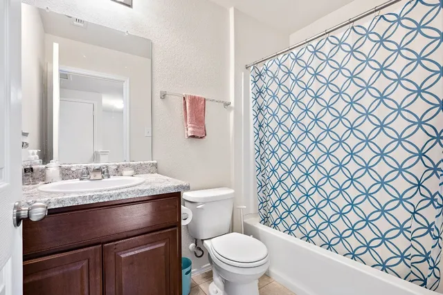 a bathroom with a granite countertop toilet sink and mirror