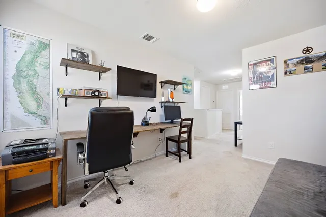 a view of a workspace with furniture and a flat screen tv