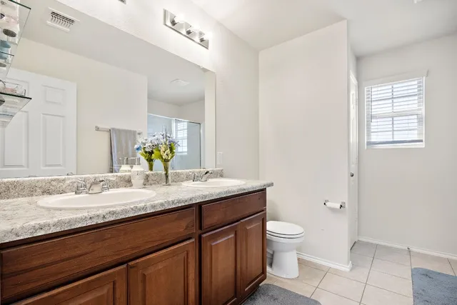 a bathroom with a granite countertop sink a toilet and a mirror