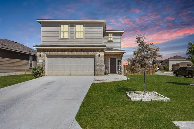 a front view of a house with a yard and garage