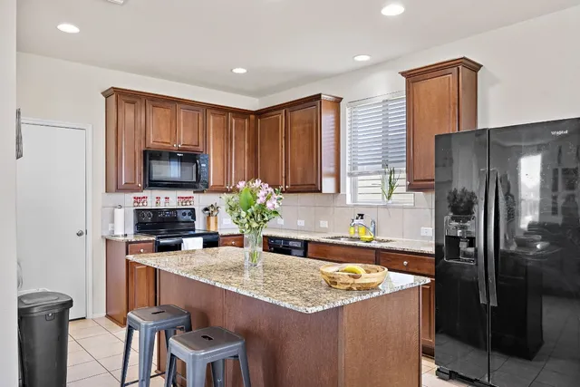 a kitchen with stainless steel appliances granite countertop a refrigerator and a stove top oven