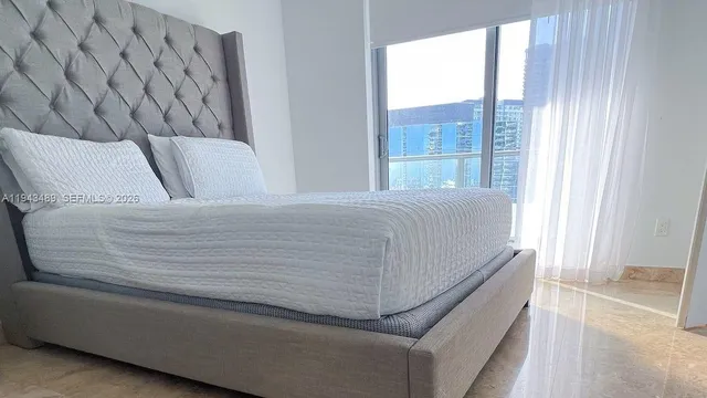 a bed sitting in a bedroom next to a window