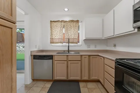 a kitchen with white cabinets appliances and a sink