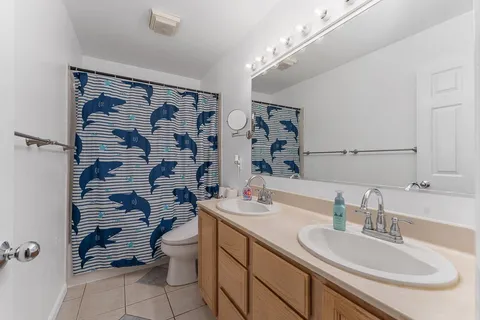 a bathroom with a double vanity sink toilet and shower