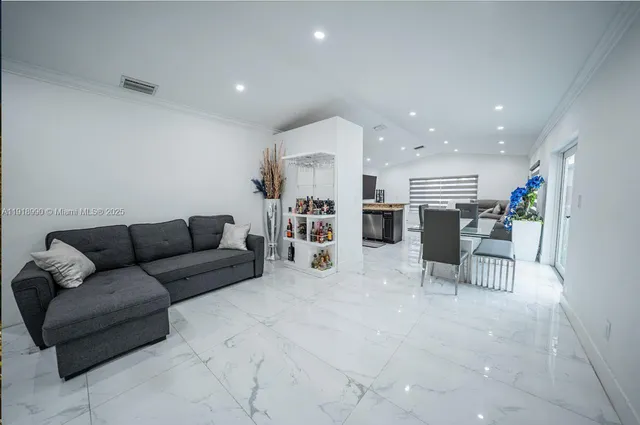 a living room with furniture and kitchen view