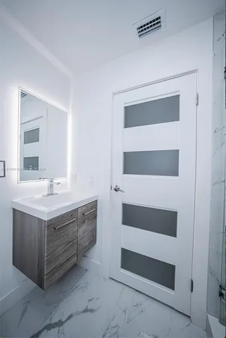 a bathroom with a sink a toilet and a mirror