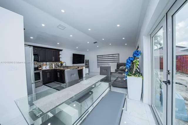 a large white kitchen with a large window a refrigerator and a stove
