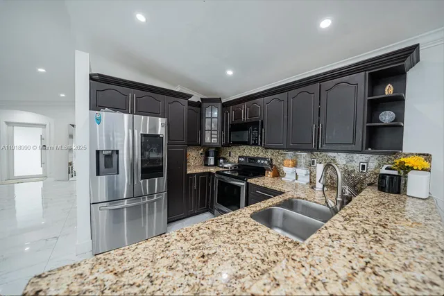 a kitchen with granite countertop a refrigerator and a sink