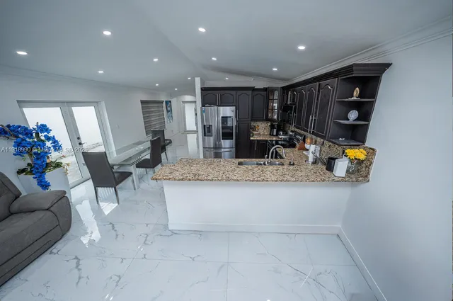 a living room with furniture and kitchen view