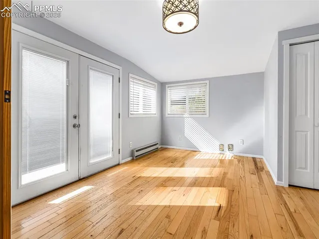 a view of a bedroom with wooden floor and windows