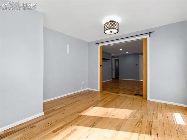 a view of a room with wooden floor and white walls
