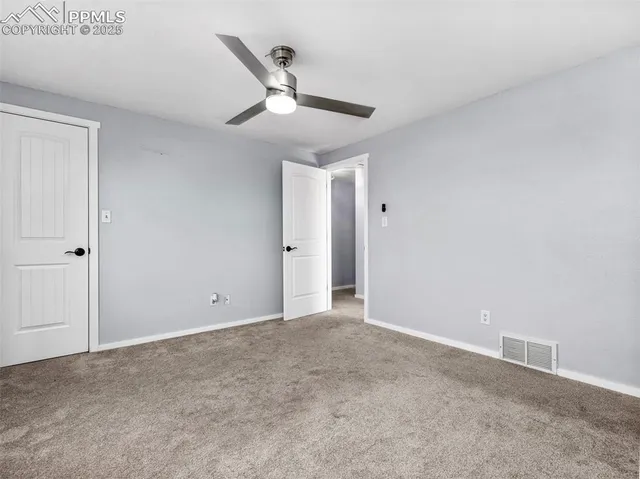 a view of an empty room with a ceiling fan