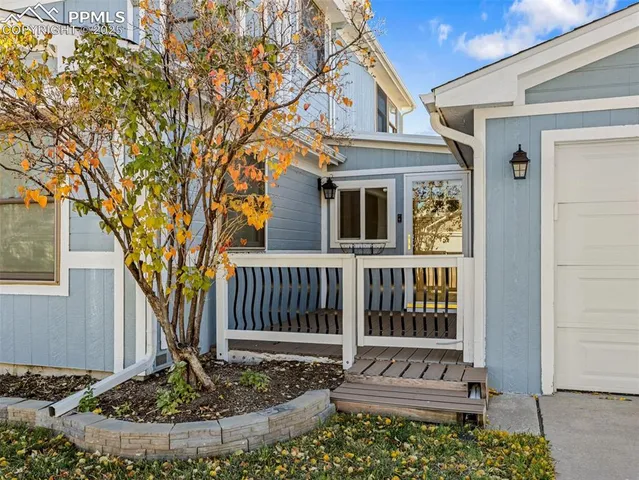 a view of a house with a small yard and wooden fence