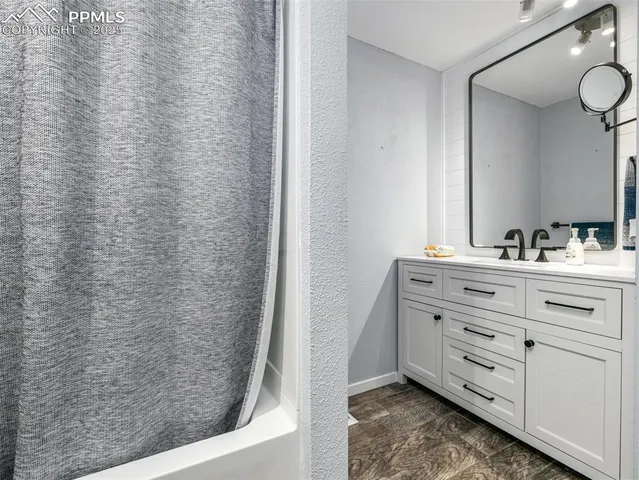 a bathroom with a granite countertop sink and a mirror