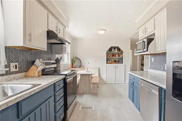 a kitchen with stainless steel appliances granite countertop a sink stove and cabinets