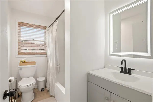 a bathroom with a toilet a sink a mirror and vanity