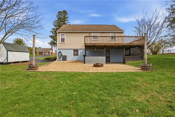 a view of a white house with a big yard and large tree