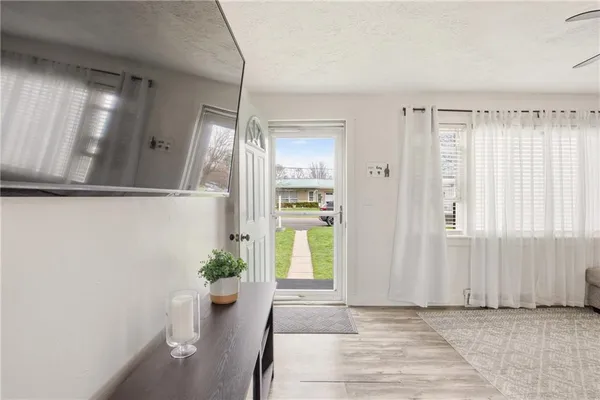 a view of hallway with window and wooden floor