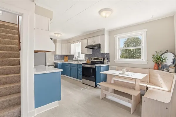 a kitchen with a refrigerator and a stove top oven