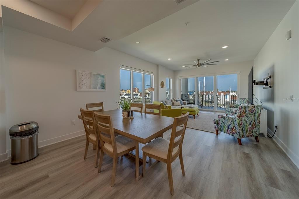 400 150th Avenue, Unit 407 Madeira Beach, FL 33708 - Photo 11 of 59 a view of a dining room with furniture and wooden floor