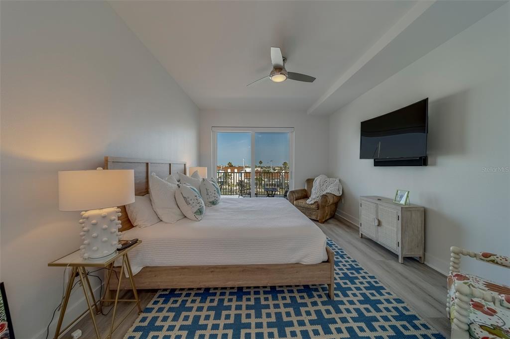 400 150th Avenue, Unit 407 Madeira Beach, FL 33708 - Photo 16 of 59 a bedroom with a bed and flat tv screen on the dresser