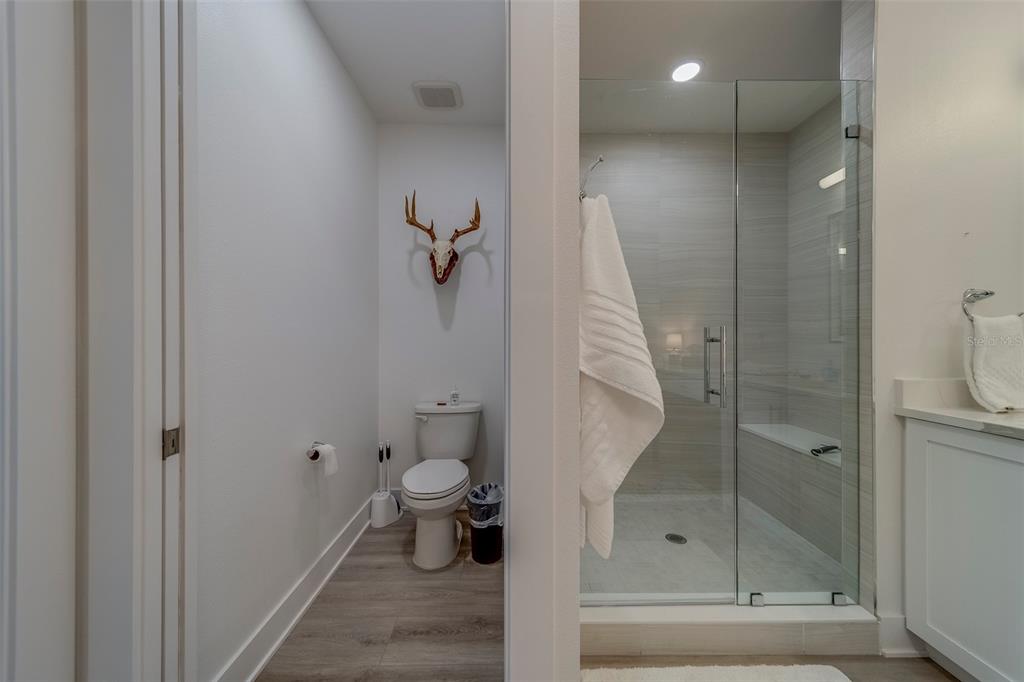 400 150th Avenue, Unit 407 Madeira Beach, FL 33708 - Photo 21 of 59 a bathroom with a shower and toilet
