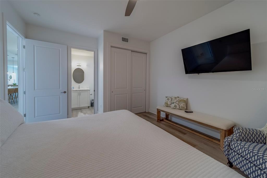 400 150th Avenue, Unit 407 Madeira Beach, FL 33708 - Photo 25 of 59 a bedroom with a bed and a flat screen tv