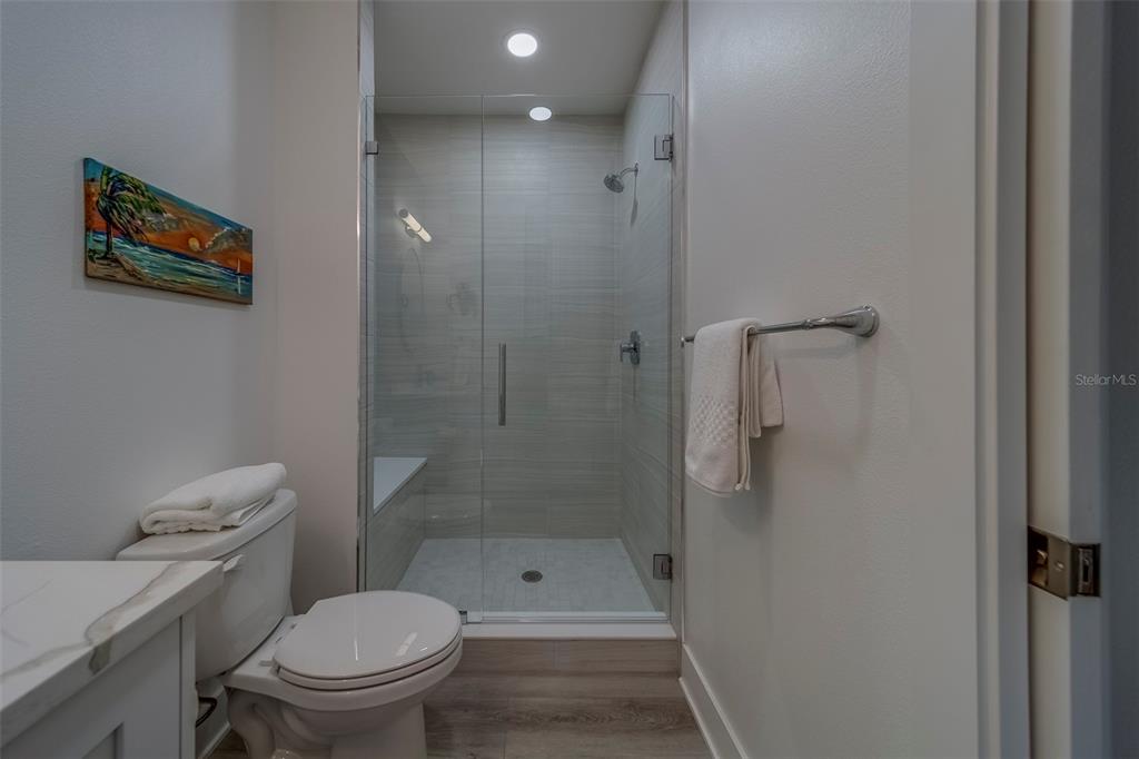 400 150th Avenue, Unit 407 Madeira Beach, FL 33708 - Photo 28 of 59 a bathroom with a granite countertop toilet a sink and shower