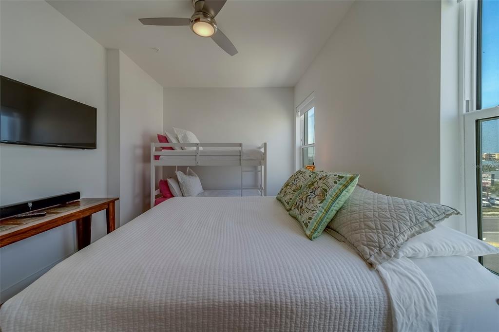 400 150th Avenue, Unit 407 Madeira Beach, FL 33708 - Photo 29 of 59 a bedroom with a bed and a flat screen tv
