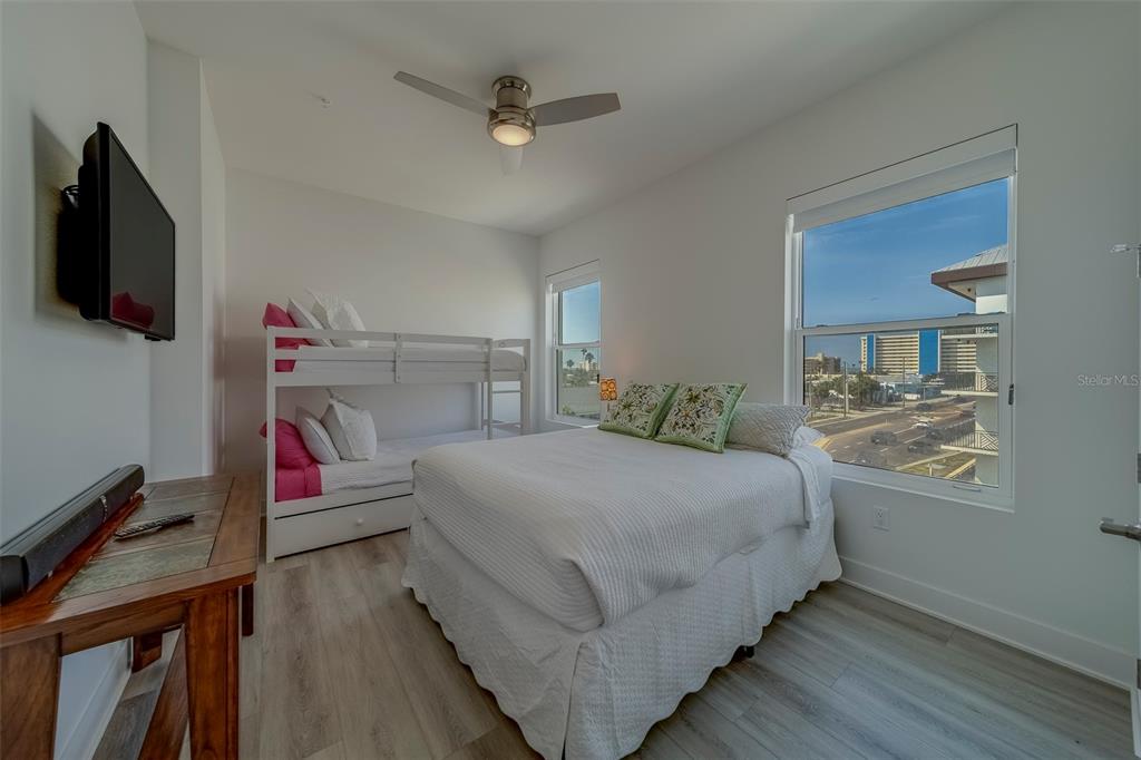 400 150th Avenue, Unit 407 Madeira Beach, FL 33708 - Photo 30 of 59 a bedroom with a bed and flat screen tv