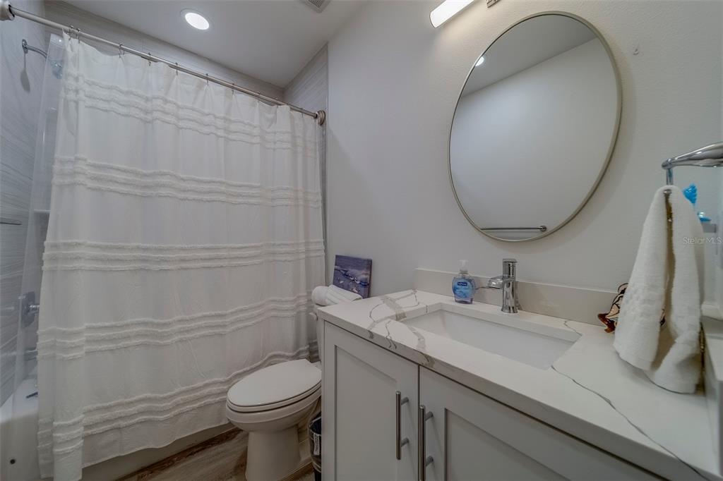 400 150th Avenue, Unit 407 Madeira Beach, FL 33708 - Photo 33 of 59 a bathroom with a sink a toilet and a mirror