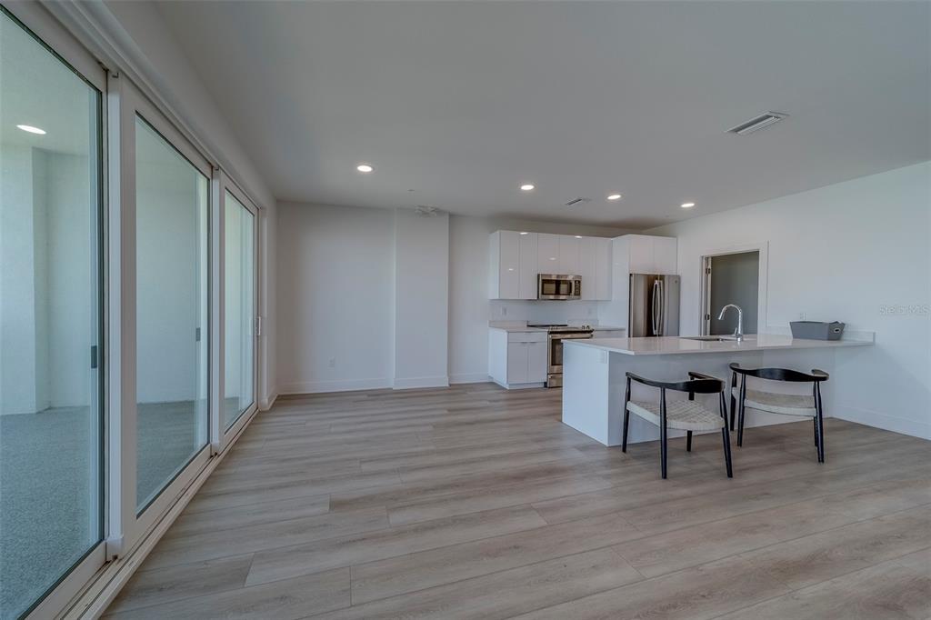 400 150th Avenue, Unit 407 Madeira Beach, FL 33708 - Photo 48 of 59 a view of kitchen with cabinets and wooden floor