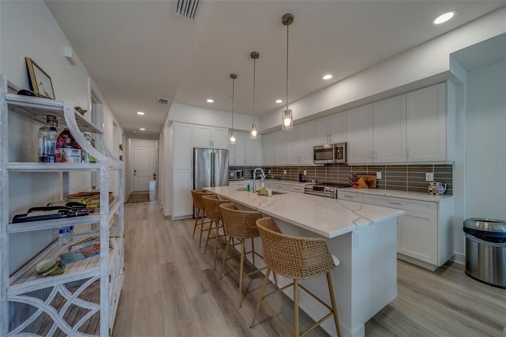 400 150th Avenue, Unit 407 Madeira Beach, FL 33708 - Photo 7 of 59 a large white kitchen with lots of counter space a sink appliances and cabinets