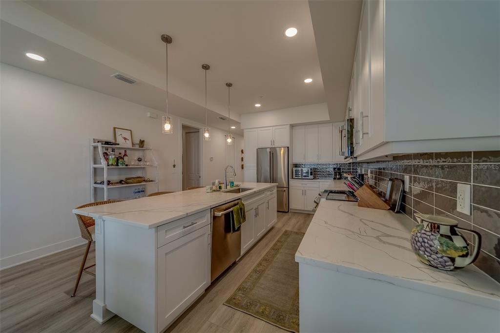 400 150th Avenue, Unit 407 Madeira Beach, FL 33708 - Photo 8 of 59 a large kitchen with stainless steel appliances lots of counter top space