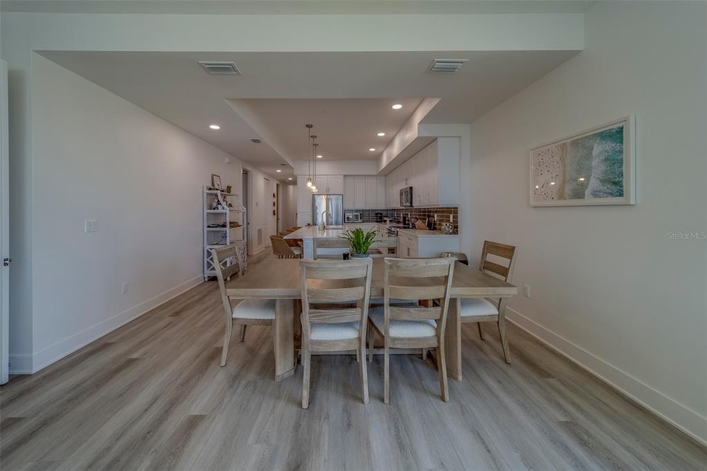 400 150th Avenue, Unit 407 Madeira Beach, FL 33708 - Photo 10 of 59 a view of a dining room with furniture and wooden floor