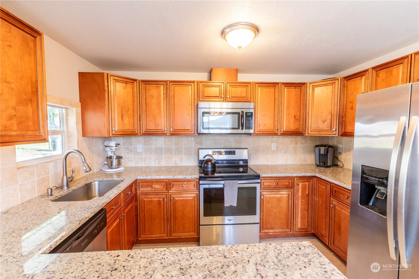 275 Patrick Road Ephrata, WA 98823 - Photo 20 of 35 a kitchen with stainless steel appliances granite countertop a sink a stove a refrigerator cabinets and a window