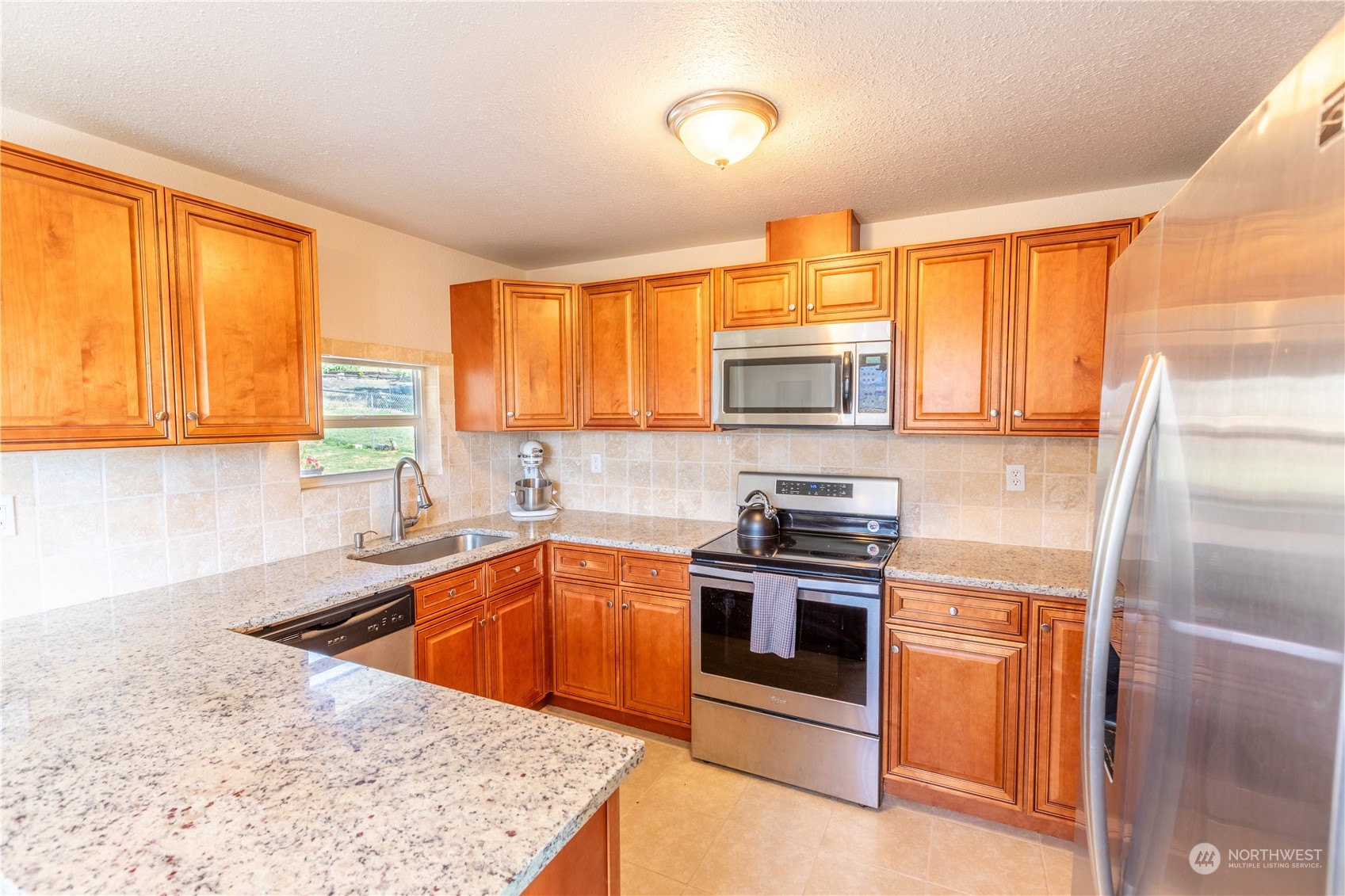 275 Patrick Road Ephrata, WA 98823 - Photo 24 of 35 a kitchen with stainless steel appliances granite countertop a sink stove refrigerator and cabinets