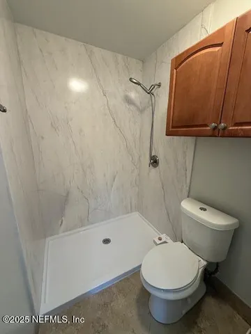 a white toilet sitting next to a bath tub shower