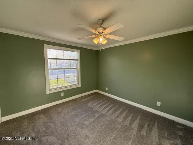 an empty room with a window and ceiling fan