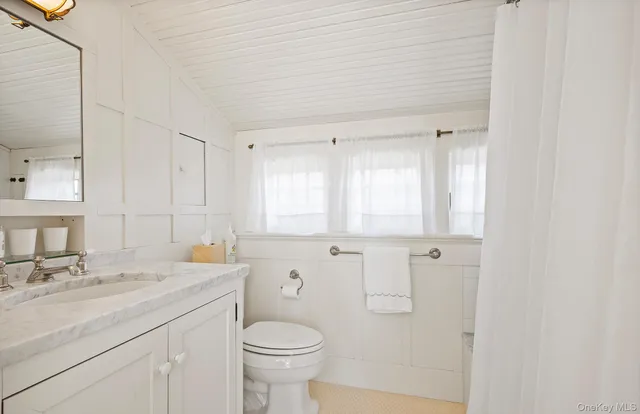 a bathroom with a granite countertop sink mirror and a window