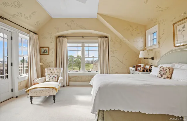 a bedroom with a bed wooden floor and windows