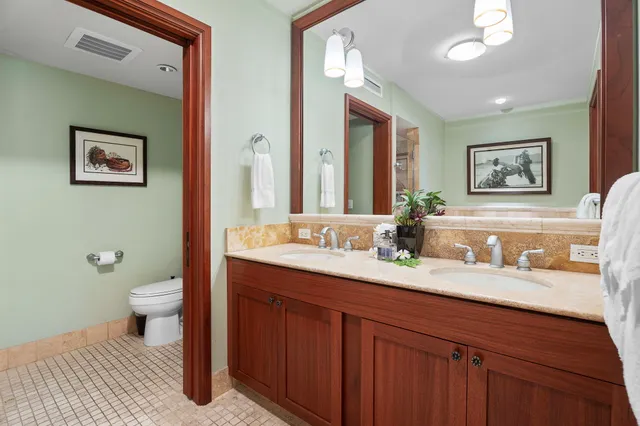 a bathroom with a granite countertop sink mirror and toilet