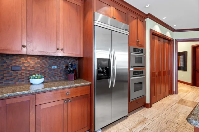a kitchen with stainless steel appliances granite countertop a refrigerator a sink and white cabinets