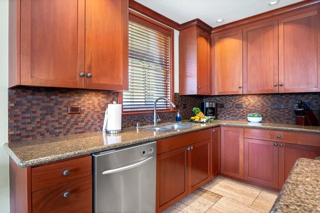 a kitchen with stainless steel appliances granite countertop wooden cabinets a sink and dishwasher