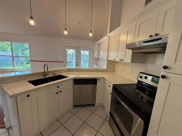 a kitchen with granite countertop a sink and a stove top oven
