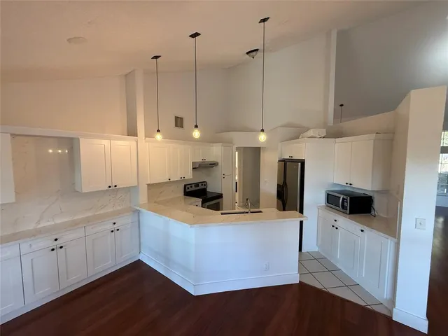 a kitchen with stainless steel appliances granite countertop a sink a stove and a refrigerator