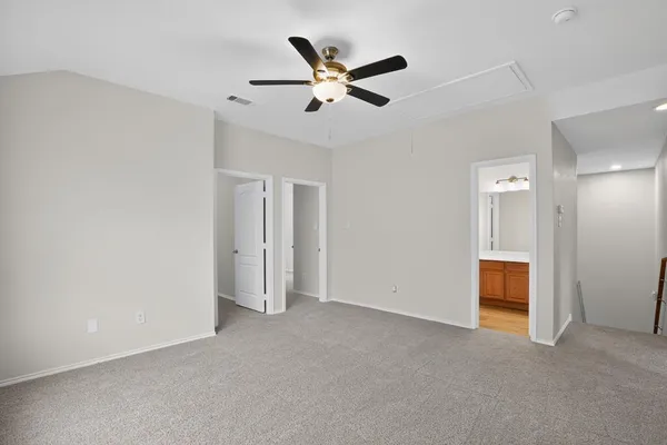 a view of an empty room with a ceiling fan